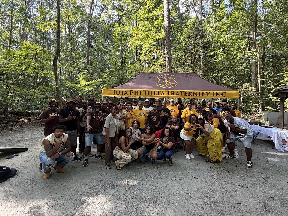 Brothers, family, and friends gather beneath the Iota Phi Theta tent.
